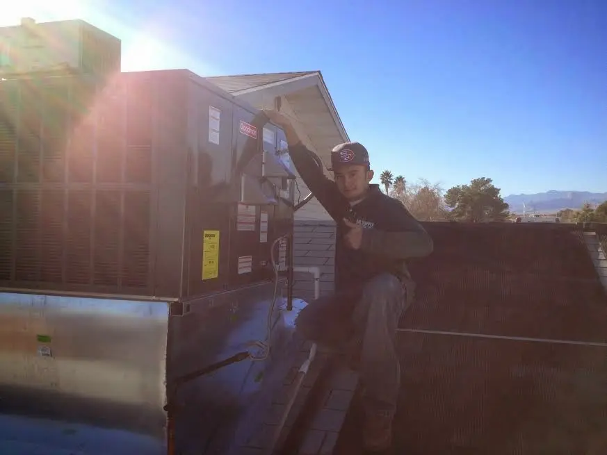HVAC technician performing AC Tune-Up on a rooftop unit in Neenah