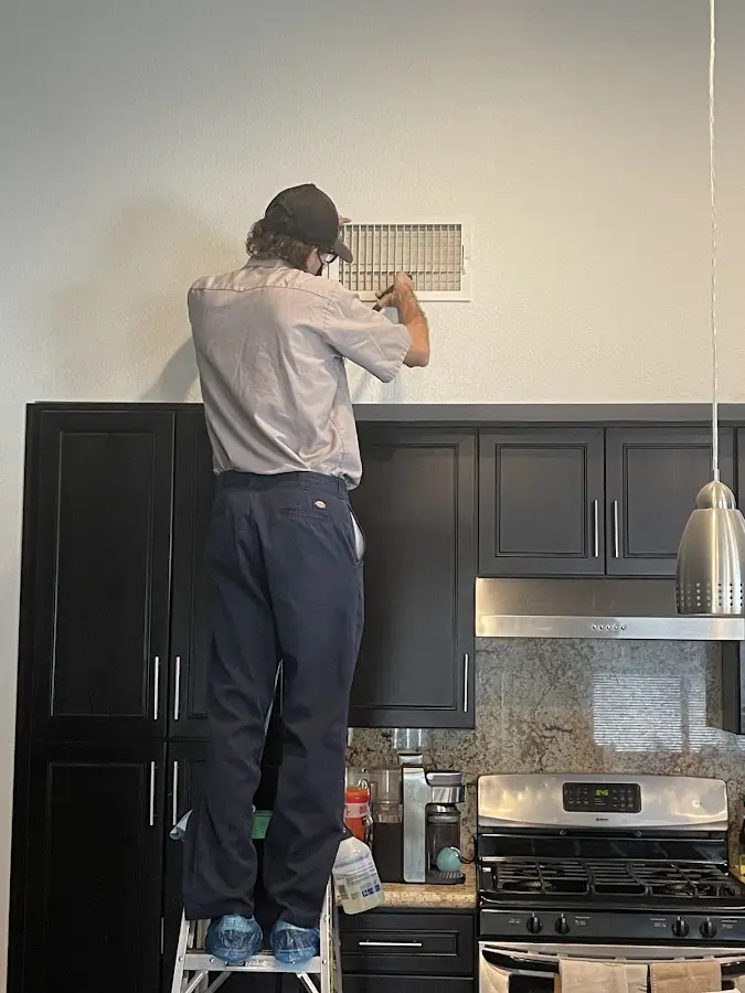 Technician inspecting an air vent during HVAC service in Neenah